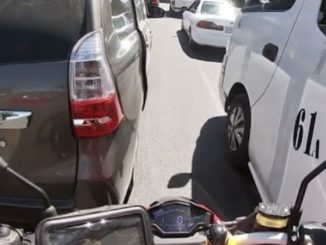 Criança pendurada na porta do carro